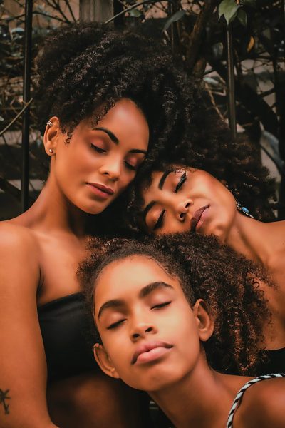 Three women together in a family leaning on each other for comfort